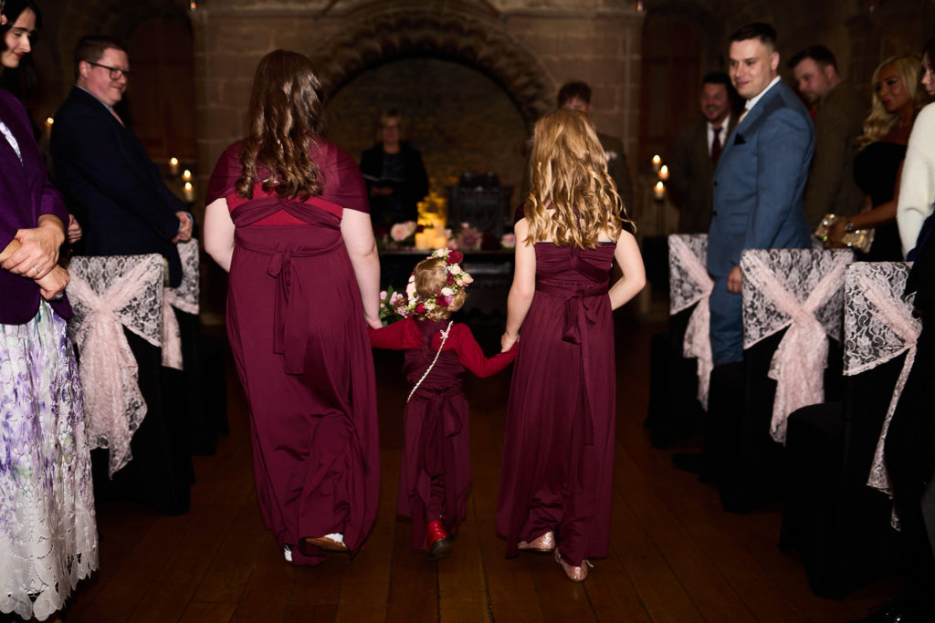 Bridesmaids and a flower girl walking up the aisle