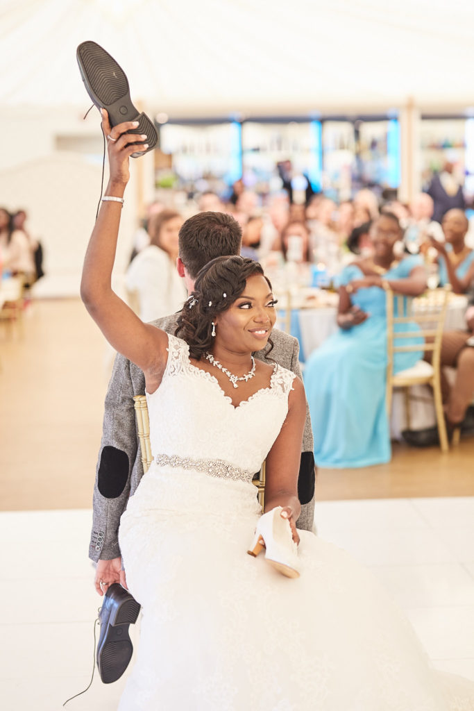 Bride holding up a shoe during the wedding shoe game