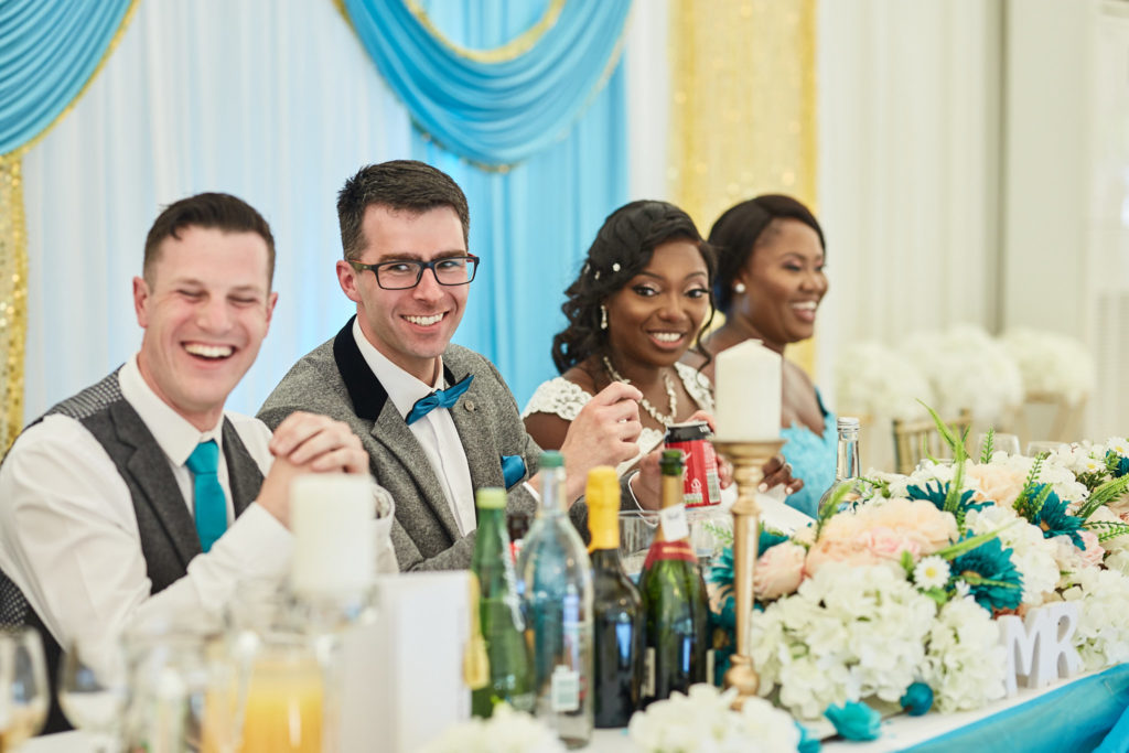 Groom and groomsmen laughing at the top table with the bride