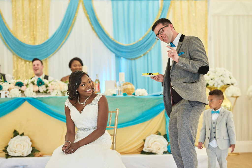 Bride seated on the dance floor as the groom and a page boy stand beside her