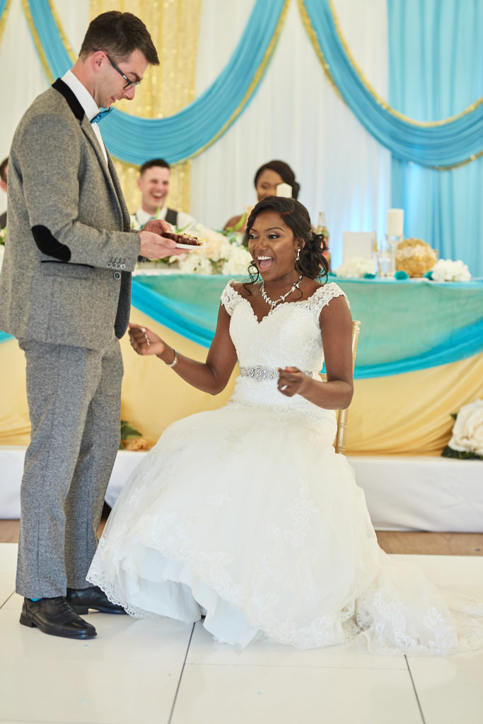 Groom reading to the laughing bride as she sits on the dance floor