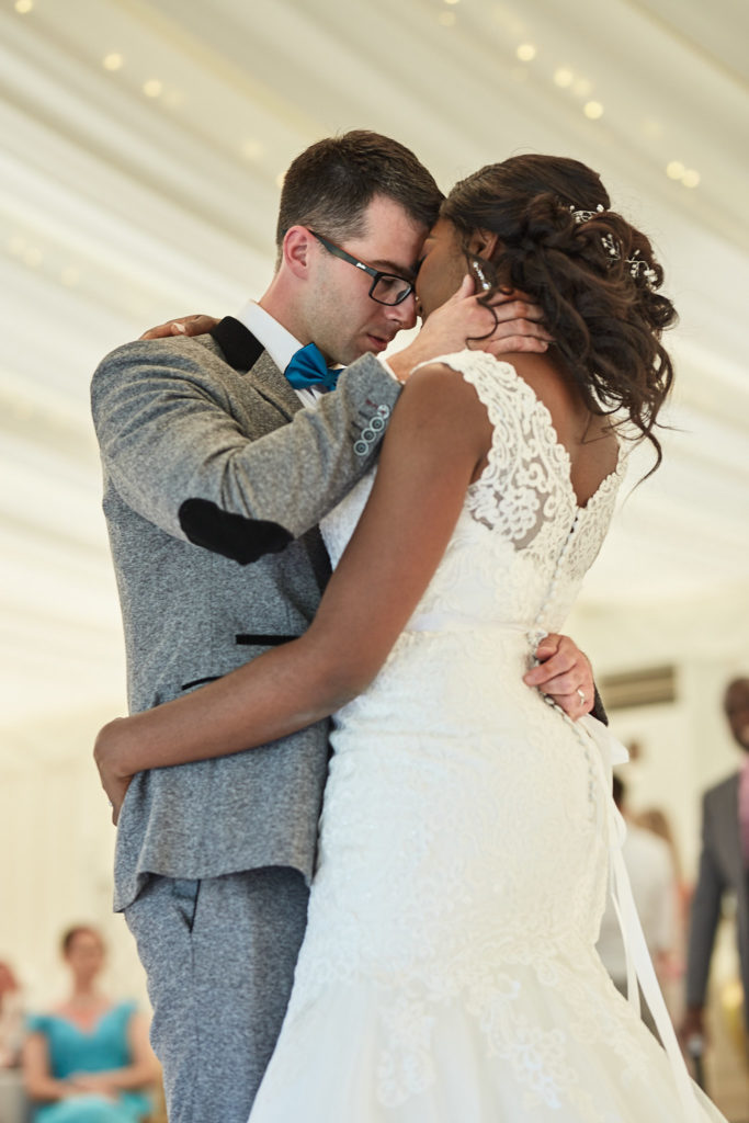 Bride and groom holding each other close during their first dance at Quendon Hall, Essex