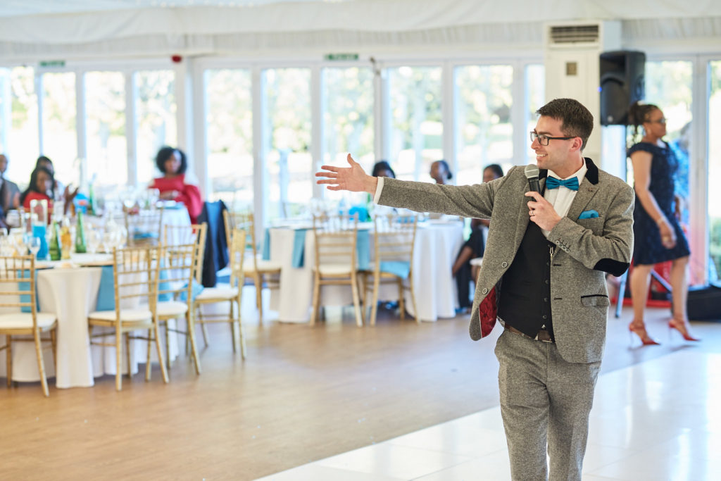Groom with his arm outstretched on the dance floor