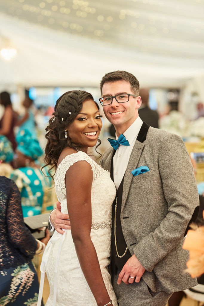 Bride and groom smiling arm in arm in the pavilion at Quendon Hall