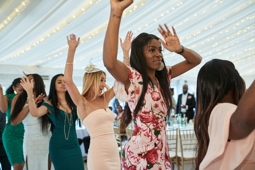 Wedding guests dancing with their arms in the air