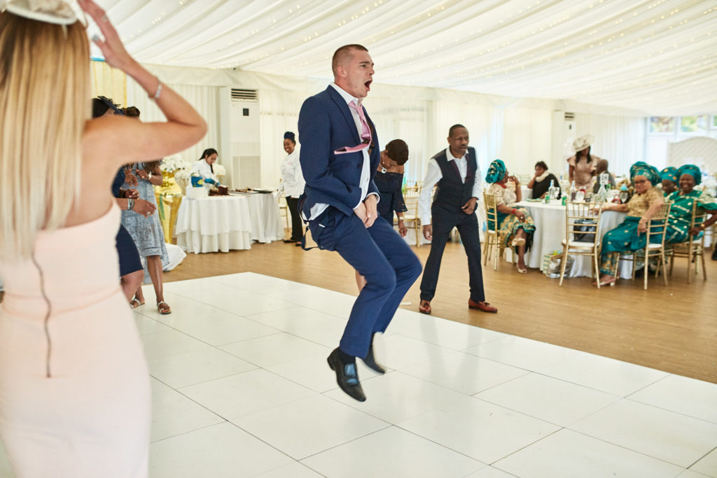 Guest in a navy suit jumping on the dance floor