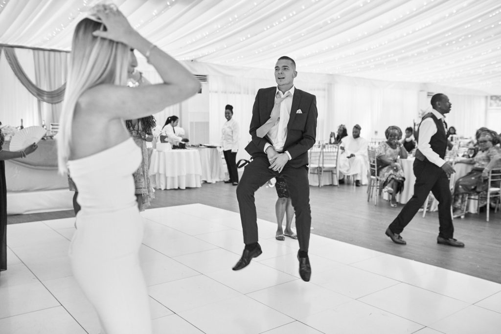 Black and white photo of a guest dancing in the middle of the dance floor