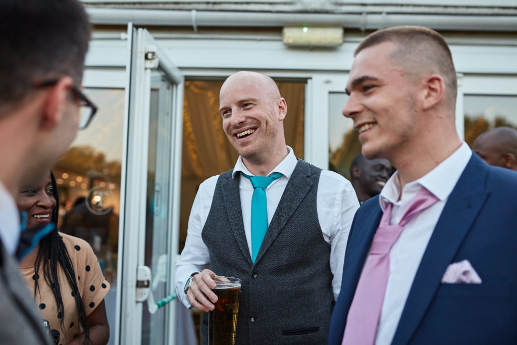 Groomsmen in waistcoats laughing together
