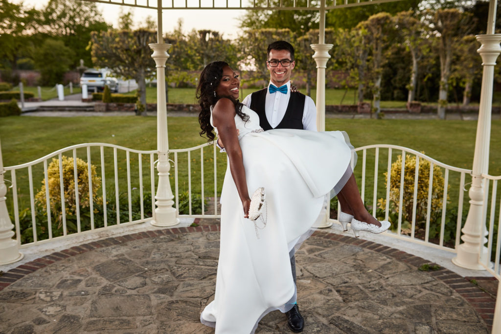 Groom lifting the bride in the bandstand at Quendon Hall