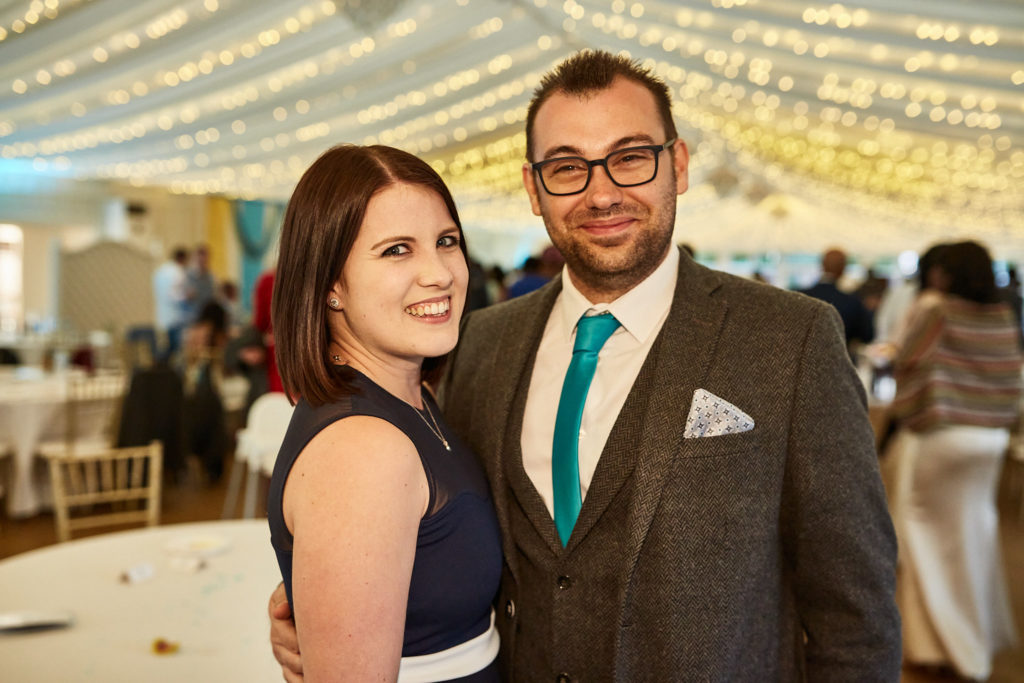 Couple smiling together under the fairy-light canopy