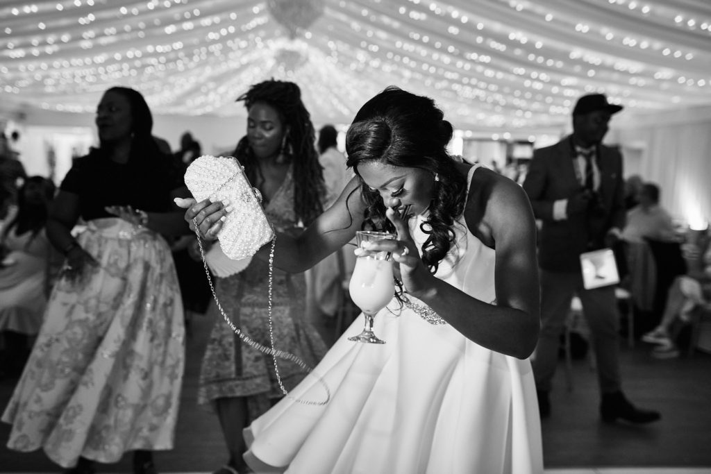 Black and white photo of the bride laughing on the dance floor in her evening dress