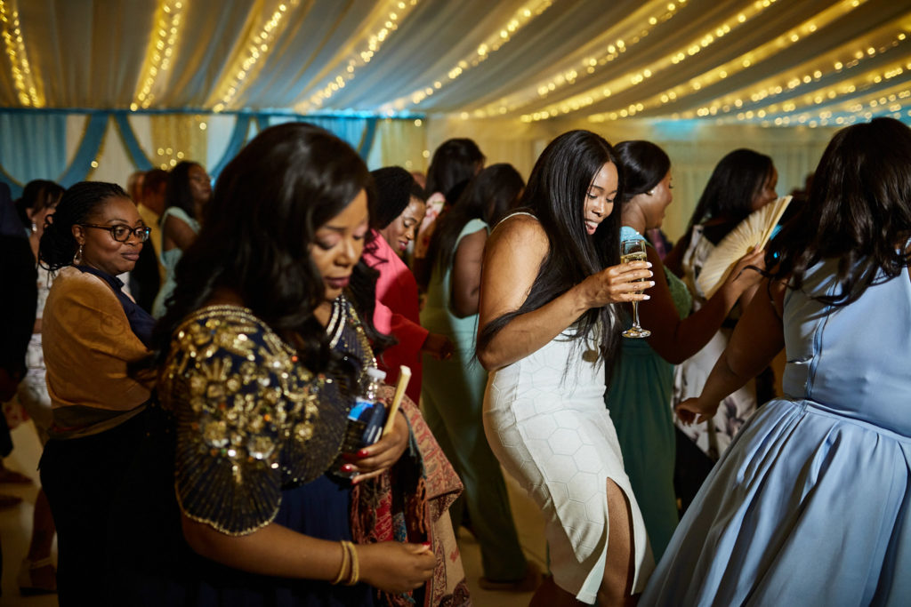 Wedding guests dancing under fairy lights in the evening