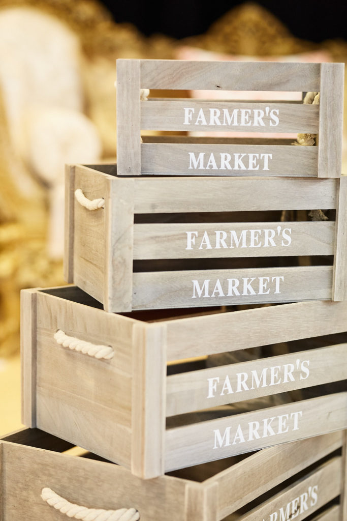 Stack of wooden "Farmer's Market" crates used as wedding decor