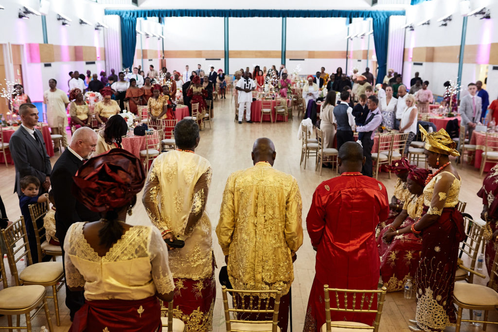 Family members in traditional dress walking into the hall at the start of the ceremony