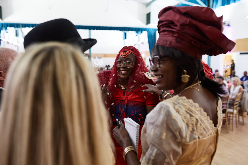Woman in a red head tie smiling during the traditional ceremony