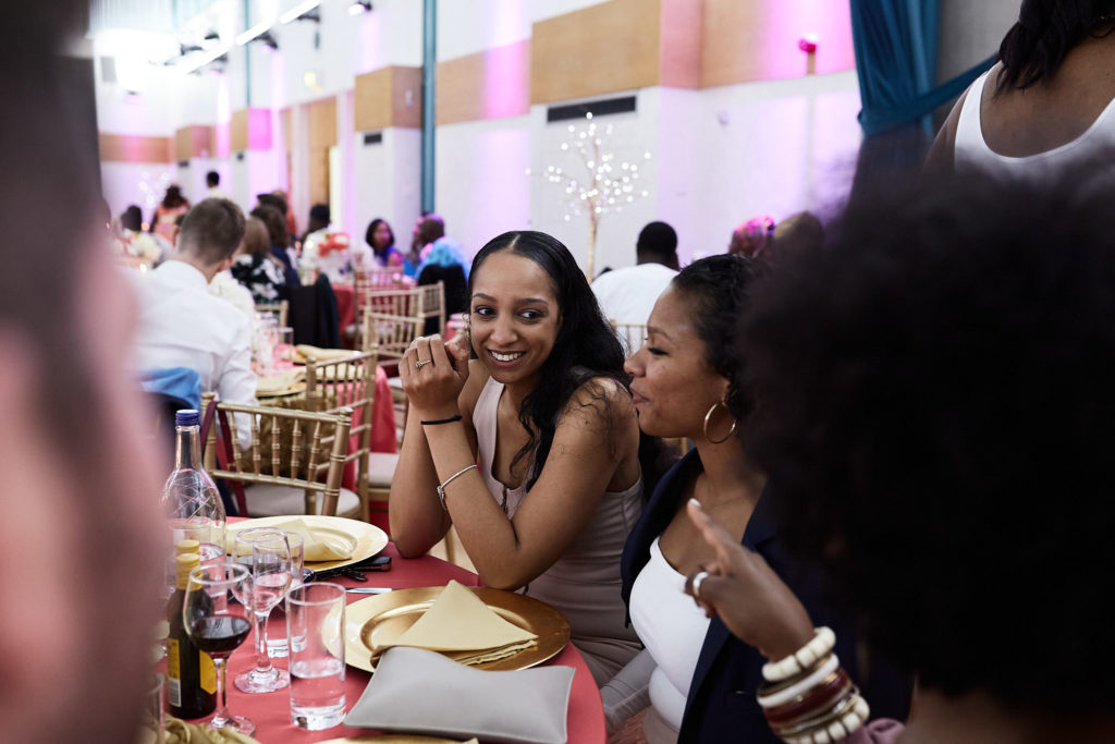 Wedding guests laughing as they watch the ceremony