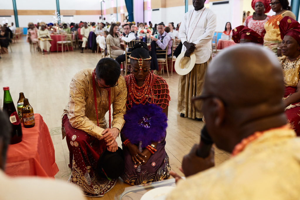 Bride and groom kneeling together before the elders