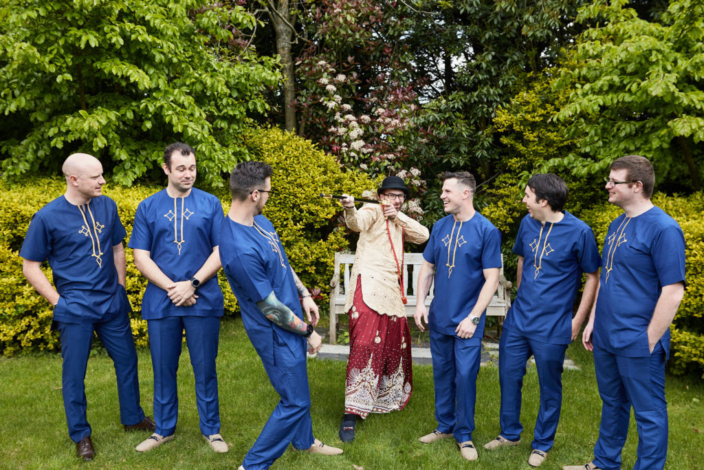 Groom and groomsmen laughing together on the lawn