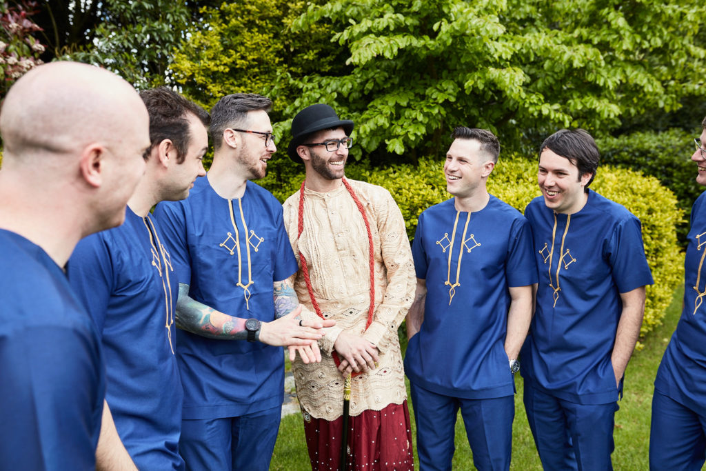 Groom chatting with his groomsmen in the garden