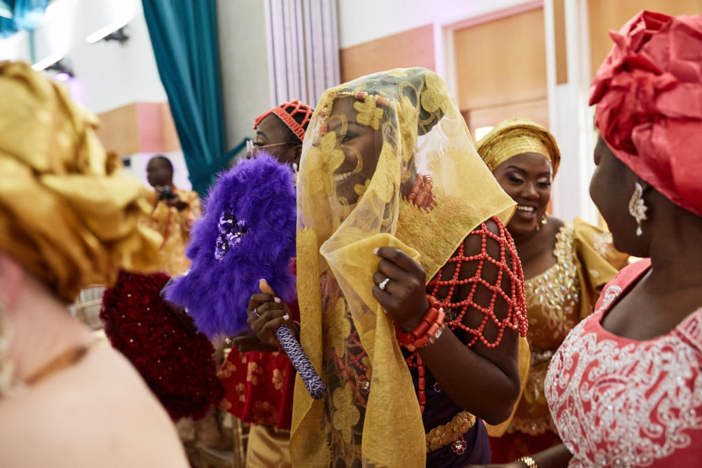 Veiled bride surrounded by women in traditional dress