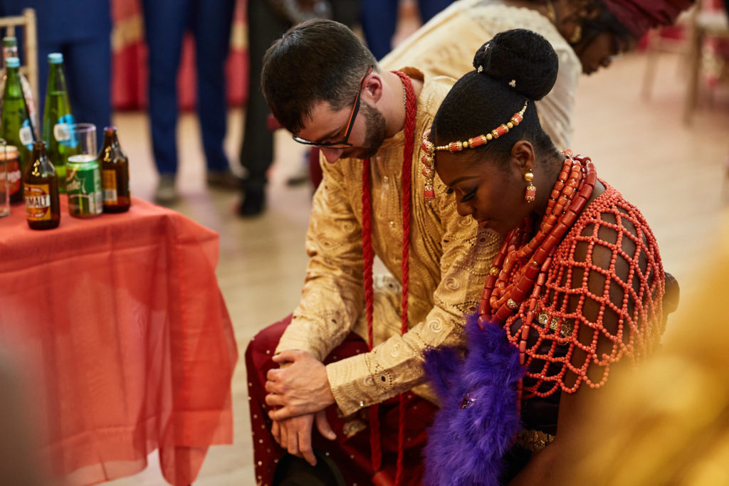 Bride and groom kneeling side by side during the traditional ceremony