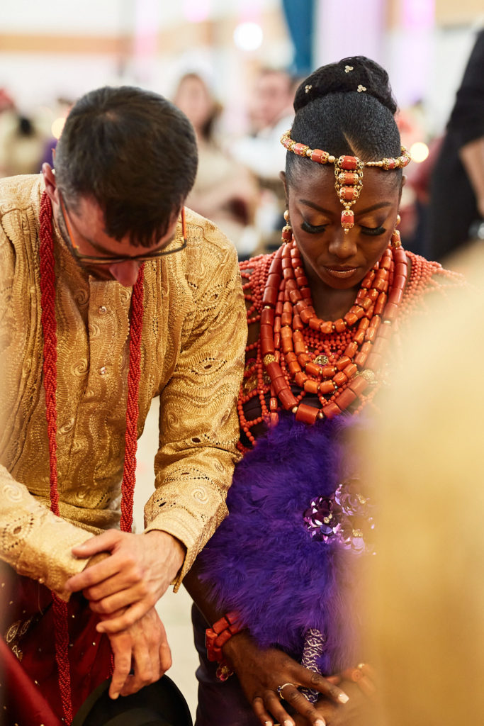 Close-up of the bride and groom kneeling with their heads bowed