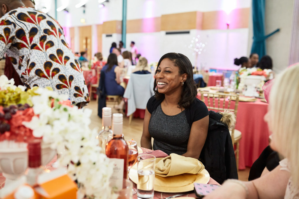 Wedding guest laughing at a table decorated with white flowers
