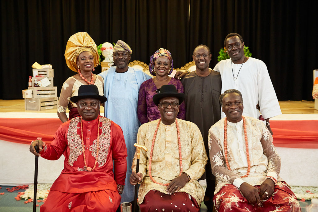 Bride's and groom's families seated together on stage in traditional dress