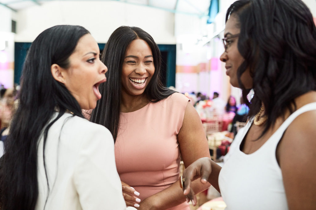Three wedding guests laughing together