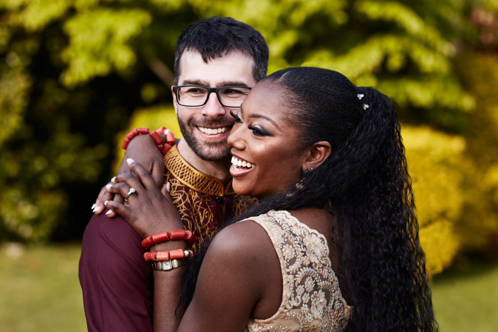 Bride and groom cuddling in the garden in evening light