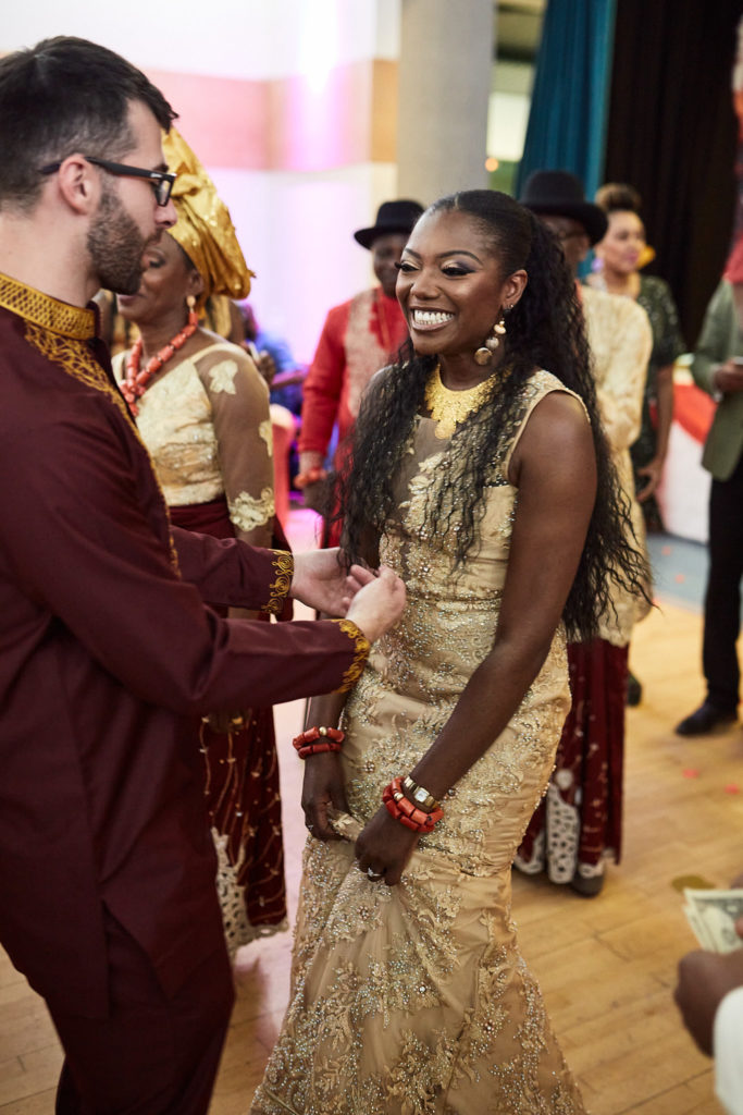 Bride in a gold lace dress dancing with the groom