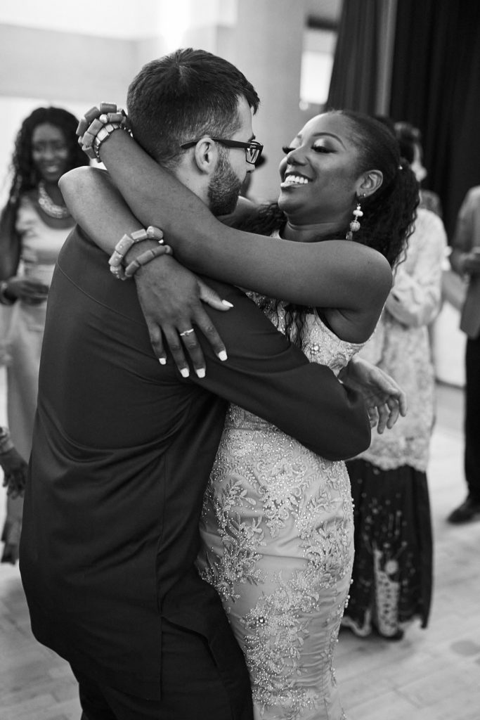 Black and white photo of the bride and groom hugging on the dance floor