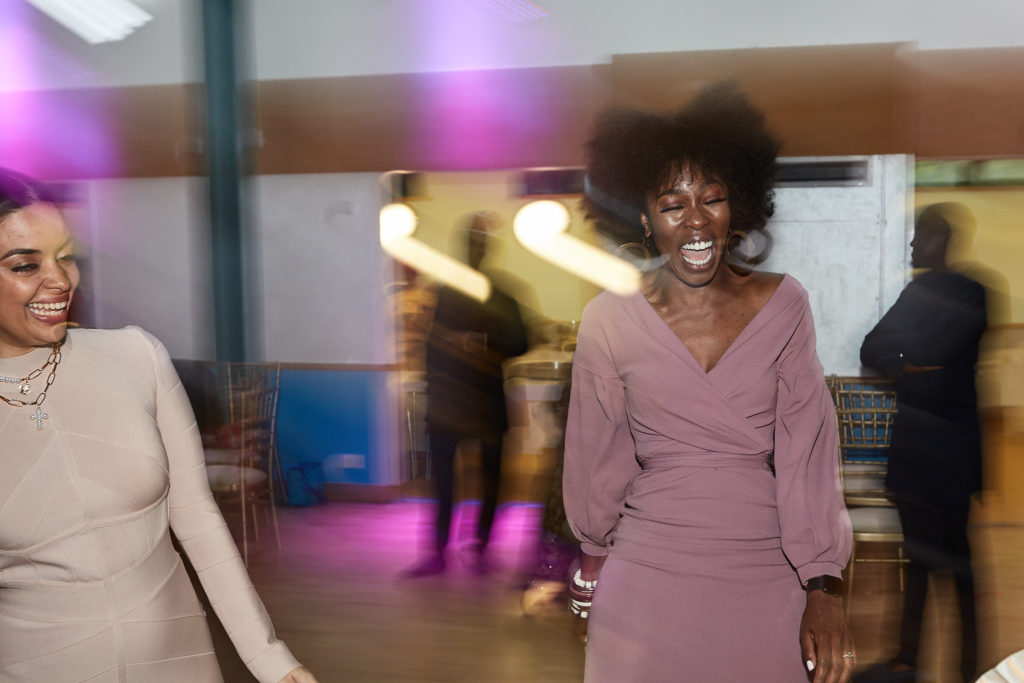 Wedding guests dancing under purple lights