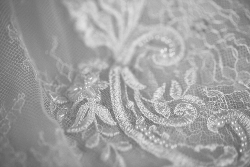 Black and white close-up of embroidered lace on the wedding dress