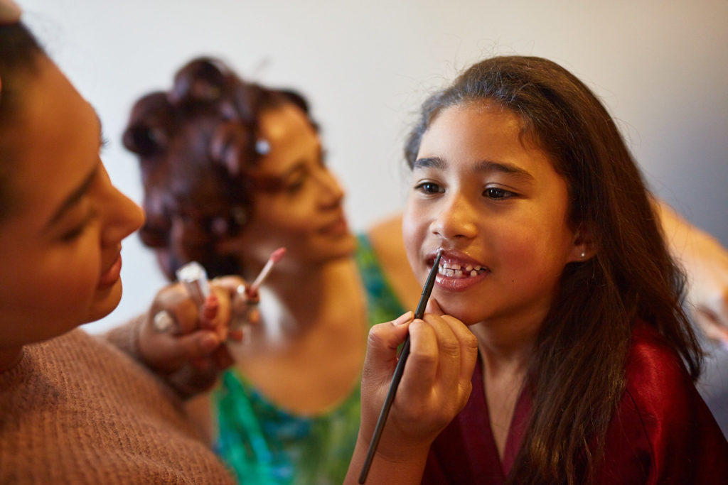 Young bridesmaid having her lipstick applied