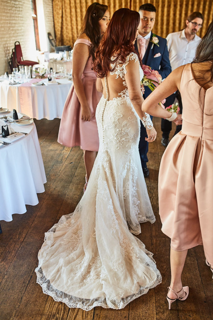 Bride from behind in her lace fishtail wedding dress as she arrives at the ceremony