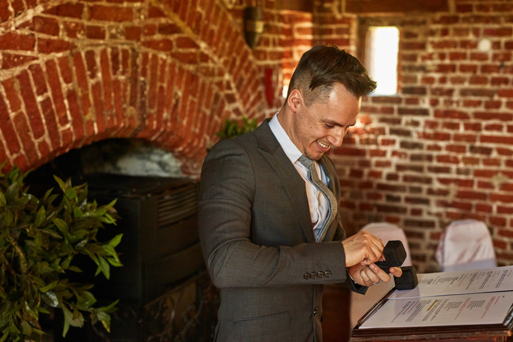 Man in a grey suit signing the register