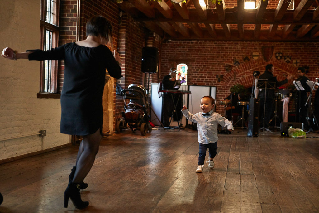 Toddler running across the dance floor towards a dancing guest