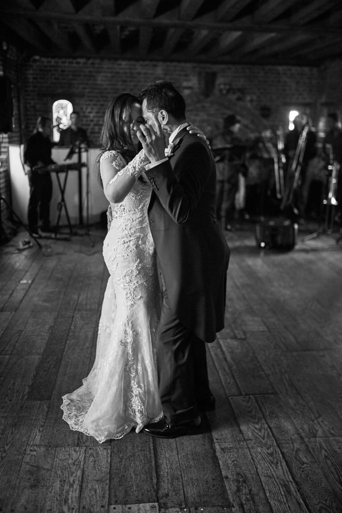 Black and white photo of the bride and groom's first dance with the band behind them