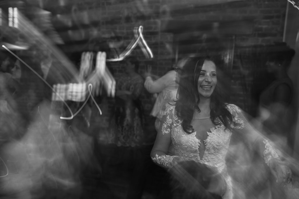 Black and white photo of the bride dancing among swirls of light