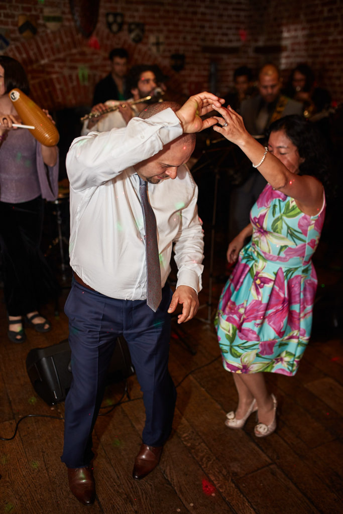 Wedding guests dancing together on the wooden dance floor