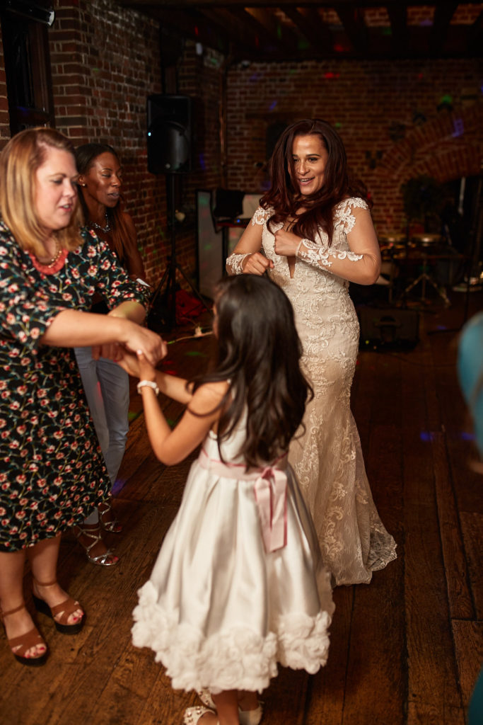 Bride dancing with a flower girl and a guest