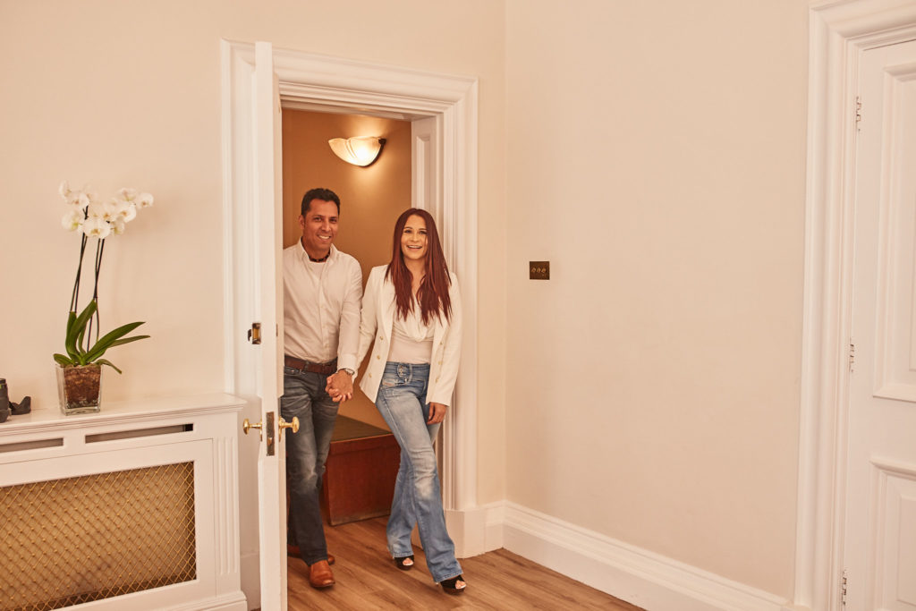 Couple in white shirts and jeans arriving through the ceremony room door