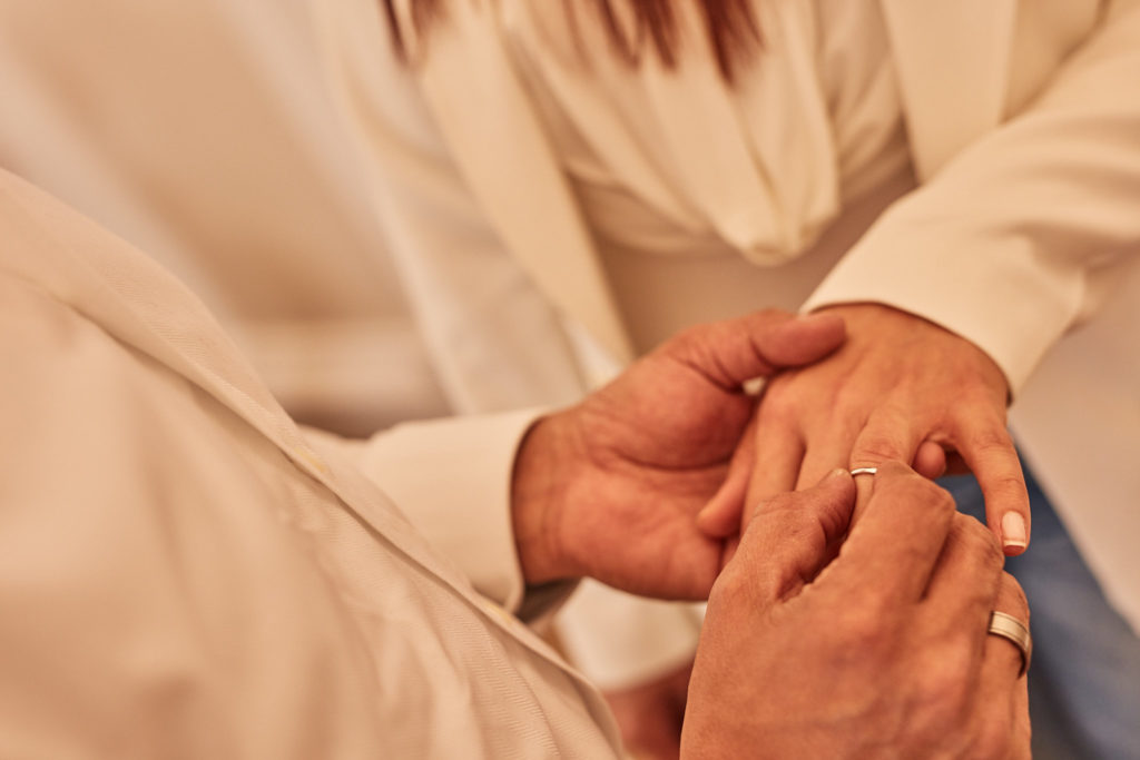 Close-up of the bride placing the ring on the groom's finger