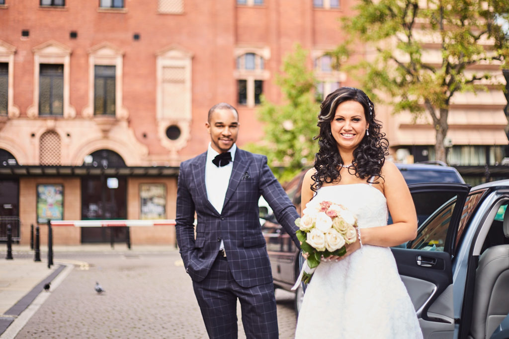 Bride and groom smiling outside St Pancras in central London