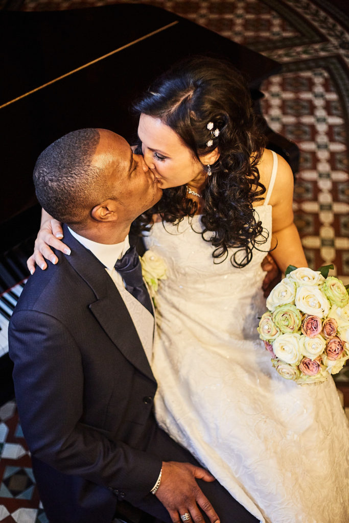 Bride kissing the groom's cheek at the St Pancras Hotel, seen from above