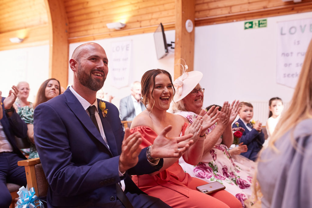 Wedding guests applauding during the ceremony