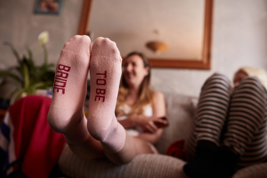 Feet in pink bridal socks propped up on the wedding morning