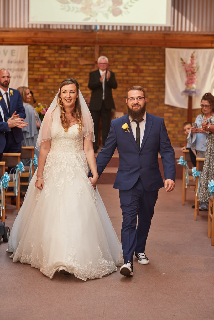 Bride and groom walking back down the aisle hand in hand