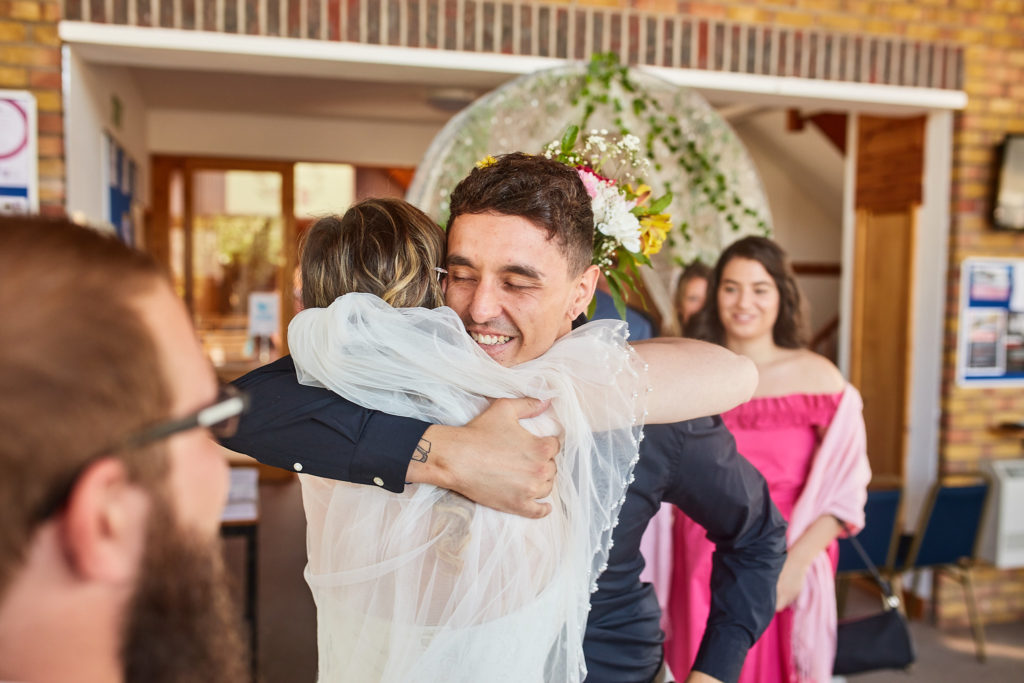 Groom hugging a guest outside the church